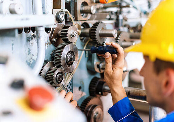 Blue collar worker or engineer working in industrial production plant, dealing with metal processing, hydraulic machinery, production lines and other processing industry machines. Image taken in Serbia, Europe.